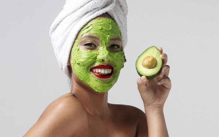 زنی در حال استفاده از پوره آووکادو به عنوان ماسک صورت